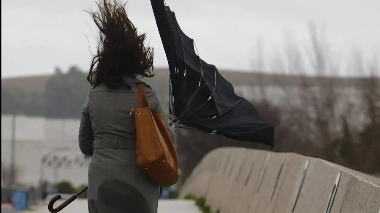 Mujer con paragüas al viento