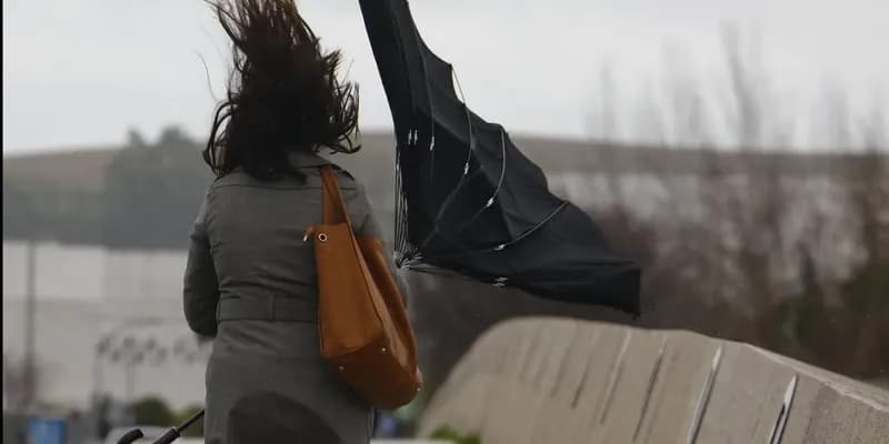 Mujer con paragüas al viento