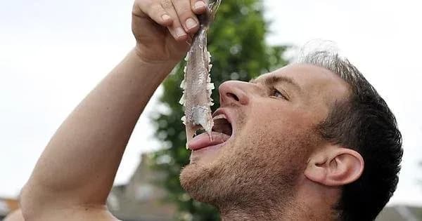 Hombre comiendo arenque holandés