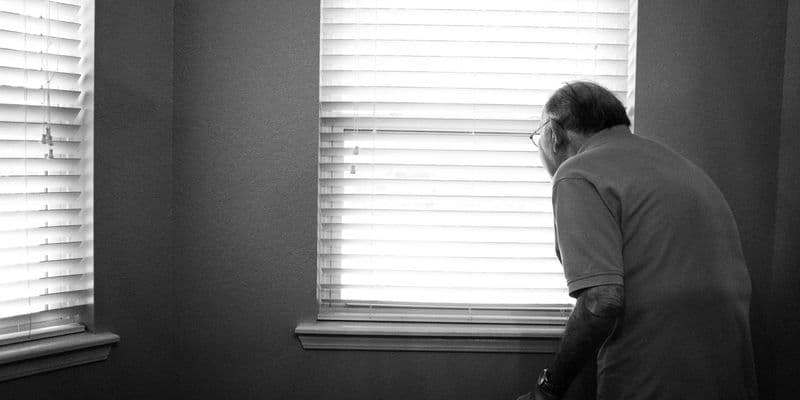 Anciano mirando por la ventana